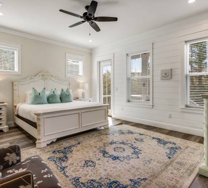 Sink into your elegant master bedroom featuring soft coastal colors, crisp linens, and gentle ceiling fan breezes for perfect sleep comfort.