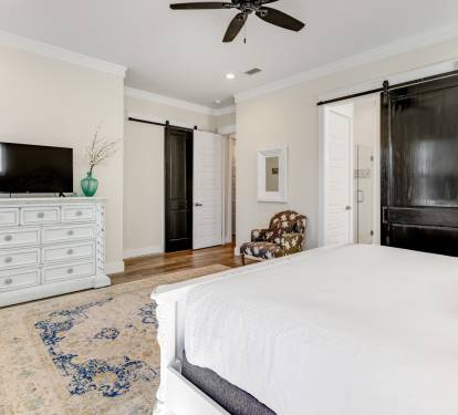 Unwind in your spacious bedroom with charming barn doors, cozy seating, and modern amenities for the perfect retreat.