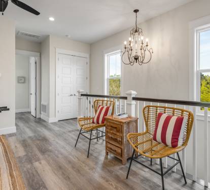 Your upstairs landing offers a charming seating nook with tree views, perfect for morning coffee or quiet moments between beach adventures.