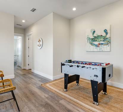 Challenge friends to foosball games in your dedicated game space, where coastal artwork and comfy seating create the perfect entertainment retreat.