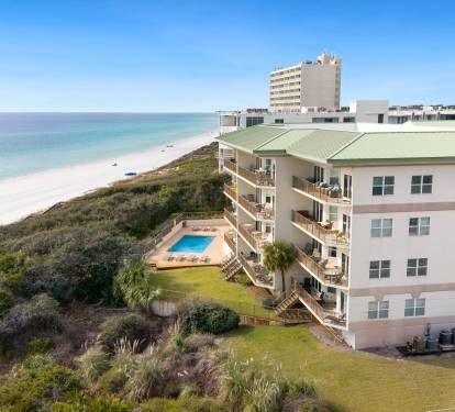 Gulf front property featuring pristine white sand beach access, swimming pool, and stunning coastal location.