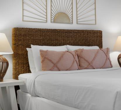 Sink into crisp white linens and soft textures in your beautifully appointed bedroom, where warm lighting creates the perfect ambiance for restful nights.