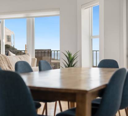 You'll love gathering around this elegant dining table with gulf views streaming through floor-to-ceiling windows.