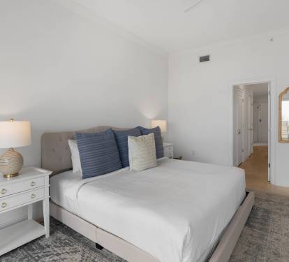 Sink into crisp white linens and plush pillows in your serene bedroom retreat, complete with coastal-inspired touches and elegant furnishings.