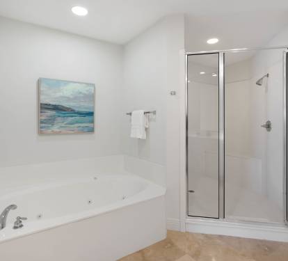 Unwind in your spa-like bathroom featuring a luxurious jetted tub and spacious glass shower, perfect for relaxing after your adventures.