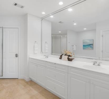 Step into your luxurious master bathroom with dual vanities, pristine white finishes, and spa-like ambiance perfect for morning routines.