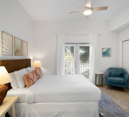 Unwind in your serene bedroom featuring a plush king bed, cozy reading chair, and stylish coastal decor that creates the perfect retreat.