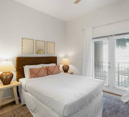 Sink into crisp white linens and wake up refreshed in this serene bedroom. Natural light filters through your private balcony doors.