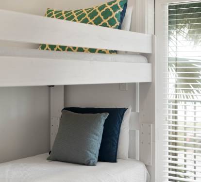 Your cozy bunk bed setup offers comfortable sleeping with stylish pillows and fresh linens, perfect for family stays.