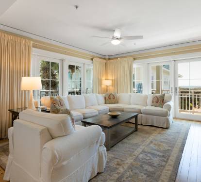 Sink into plush white sofas in your bright living room, where warm lighting and ocean breezes create the perfect retreat.