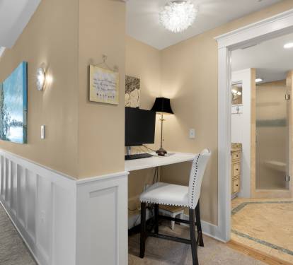 Your private workspace awaits with elegant touches and a stunning chandelier overhead, while the nearby bathroom provides luxury convenience.