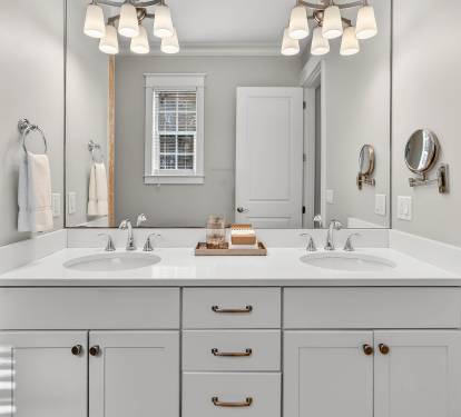 Step into your private spa-like bathroom with dual vanities, elegant lighting, and fresh towels awaiting your arrival.