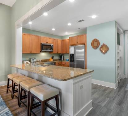 Your open-concept kitchen flows seamlessly into the living space, featuring granite countertops, stainless appliances, and a breakfast bar perfect for morning coffee.