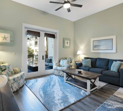 Sink into comfortable coastal-inspired furnishings while ocean breezes flow through your private balcony doors in this serene living space.