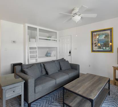 Your bright living room features a comfy sofa, entertainment center, and built-in bunk beds for extra guests.