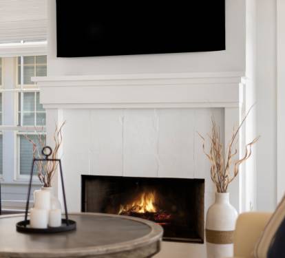 Cozy up in your elegant living room where crackling flames warm the space while you relax on plush seating.