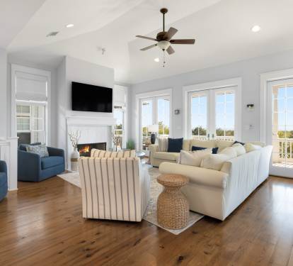 Relax in your spacious living room with cozy fireplace, comfortable seating, and stunning balcony views through floor-to-ceiling windows.