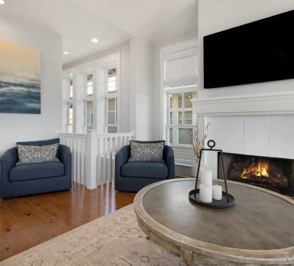 Unwind in your elegant living space with a cozy fireplace, plush seating, and entertainment center for perfect evening relaxation.