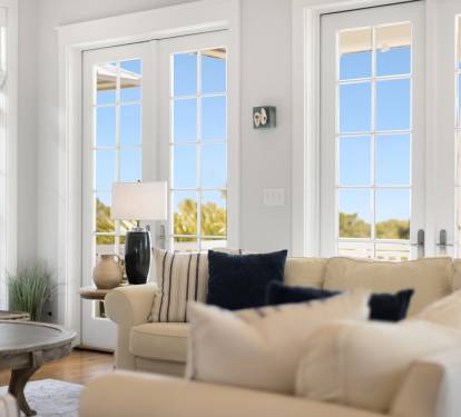 Sink into plush sofas while natural light floods your bright living space through elegant French doors opening to your private balcony.