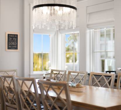 Gather around this elegant dining table where your group can share memorable meals beneath the sparkling chandelier.