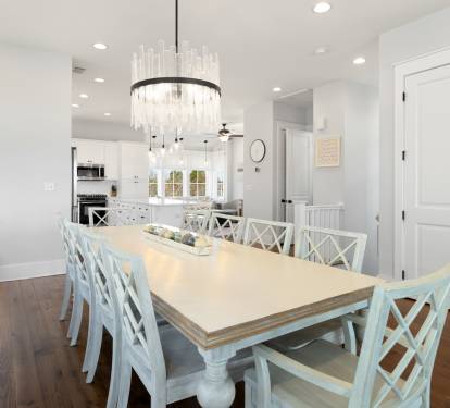 Gather around your elegant dining table for memorable meals beneath a stunning chandelier in this bright, open space.