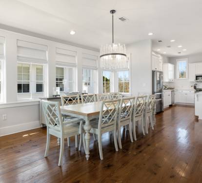 Gather around your elegant dining table with crystal chandelier overhead, then step into your fully-equipped white kitchen with modern appliances and island seating.