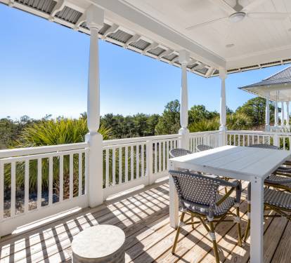 Relax on your private covered balcony with dining table, surrounded by lush tropical greenery and peaceful treetop views.