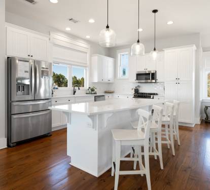 Your spacious kitchen features gleaming white cabinets, stainless appliances, and a breakfast bar where you can start mornings with coffee.