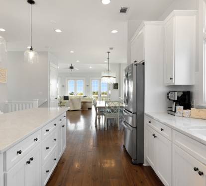 Cook and gather in your bright, airy kitchen featuring gleaming white cabinets, spacious counters, and warm hardwood floors.