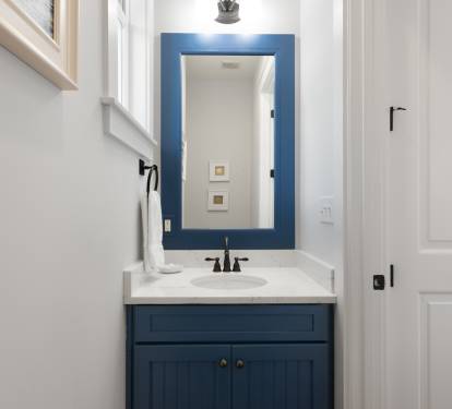Step into your elegant powder room featuring a striking navy vanity and pristine marble countertop, perfectly designed for your comfort.