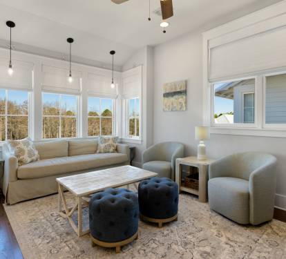 Unwind in your bright living space with plush seating and peaceful treetop views through oversized windows.