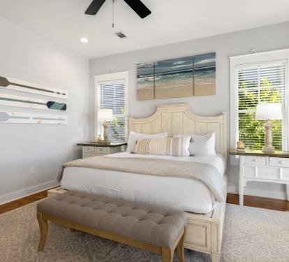 Drift into peaceful sleep in this serene bedroom with coastal artwork, plush bedding, and gentle natural light filtering through your windows.