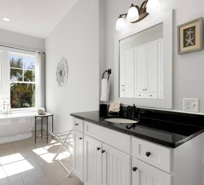 Your elegant bathroom retreat features a luxurious soaking tub where you can unwind while enjoying natural light streaming through windows.