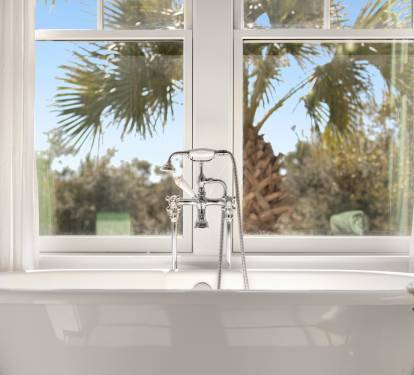 Soak in your elegant freestanding tub while gazing at swaying palms through bright windows—your perfect tropical retreat awaits.