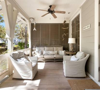 Your private covered porch invites relaxation with plush seating, ceiling fans, and peaceful neighborhood views.