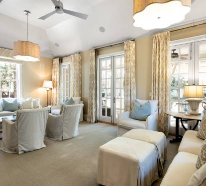 Sink into plush seating where elegant gold curtains frame natural light, creating your perfect retreat for relaxation and conversation.