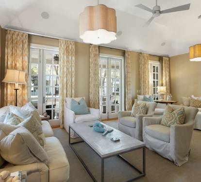 Sink into plush sofas and armchairs in your elegant living room, where soft lighting and French doors create a serene retreat.