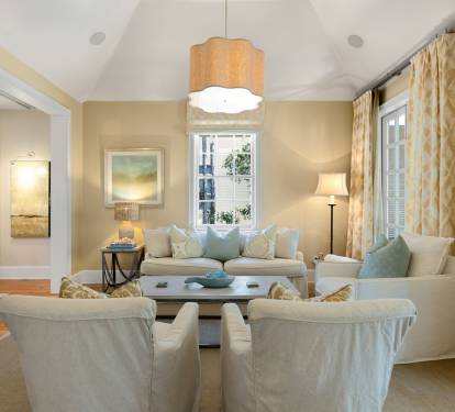 Your elegant living room awaits with plush seating, warm lighting, and peaceful views through tall windows.