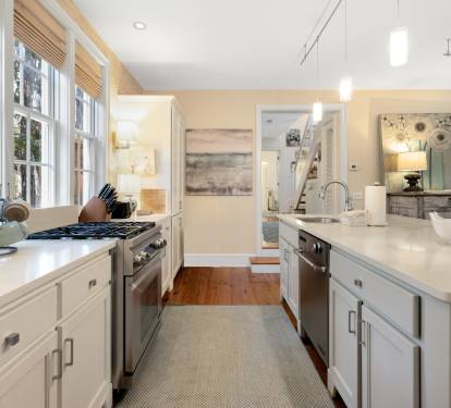 Cook with ease in this bright, open kitchen featuring modern appliances and pristine countertops flooded with natural light.