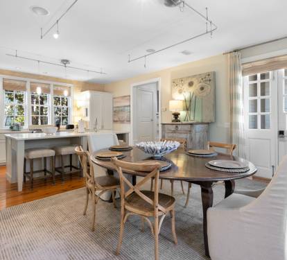 Gather around this elegant dining table where warm hardwood floors and natural light create the perfect setting for your memorable meals together.