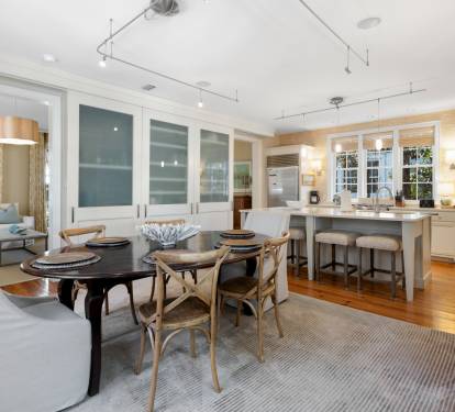 Gather around this elegant dining table where memorable meals unfold, while your culinary adventures await in the spacious, well-appointed kitchen nearby.