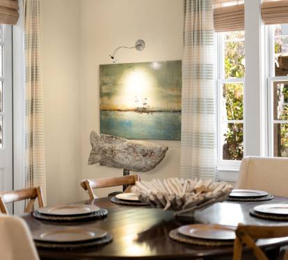 Gather around this elegant dining table where natural light streams through French doors, creating the perfect setting for memorable meals together.
