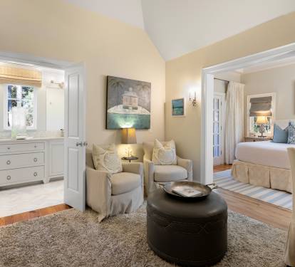 Your elegant suite features a cozy seating area with soft armchairs, perfect for unwinding after exploring the area.