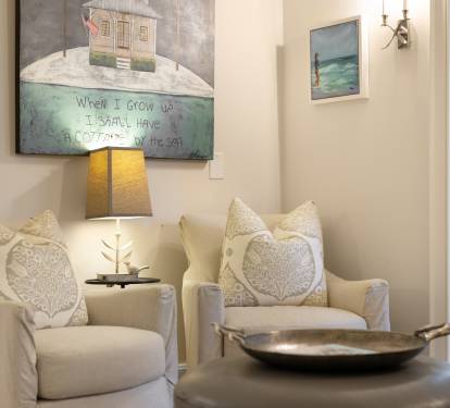 Sink into these plush armchairs and let the coastal artwork transport you to seaside serenity in your thoughtfully decorated retreat.