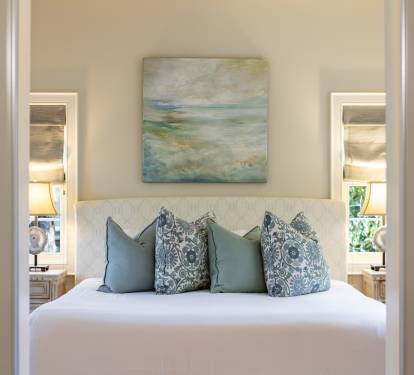 Slip into your serene bedroom sanctuary where ocean-inspired artwork and soft blue pillows create the perfect coastal retreat for restful nights.