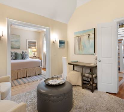 Relax in your elegant suite where coastal charm meets comfort—your private bedroom awaits beyond the inviting sitting area.