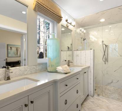 Indulge in luxury with this spa-like bathroom featuring dual vanities, elegant marble shower, and soothing coastal touches.
