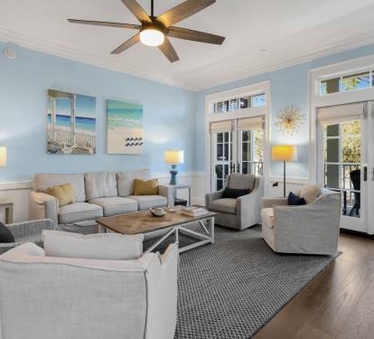 Relax in your beautifully appointed living room with coastal charm, plush seating, and French doors opening to your private balcony.