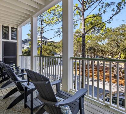Relax on your private covered porch with comfortable Adirondack chairs, overlooking peaceful wooded surroundings perfect for morning coffee.
