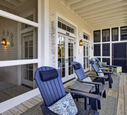 Unwind on your private covered porch with comfortable navy Adirondack chairs, perfect for morning coffee or evening relaxation.